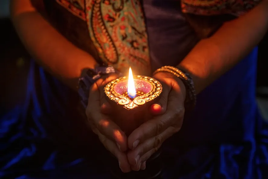 manos recogiendo una vela encendida